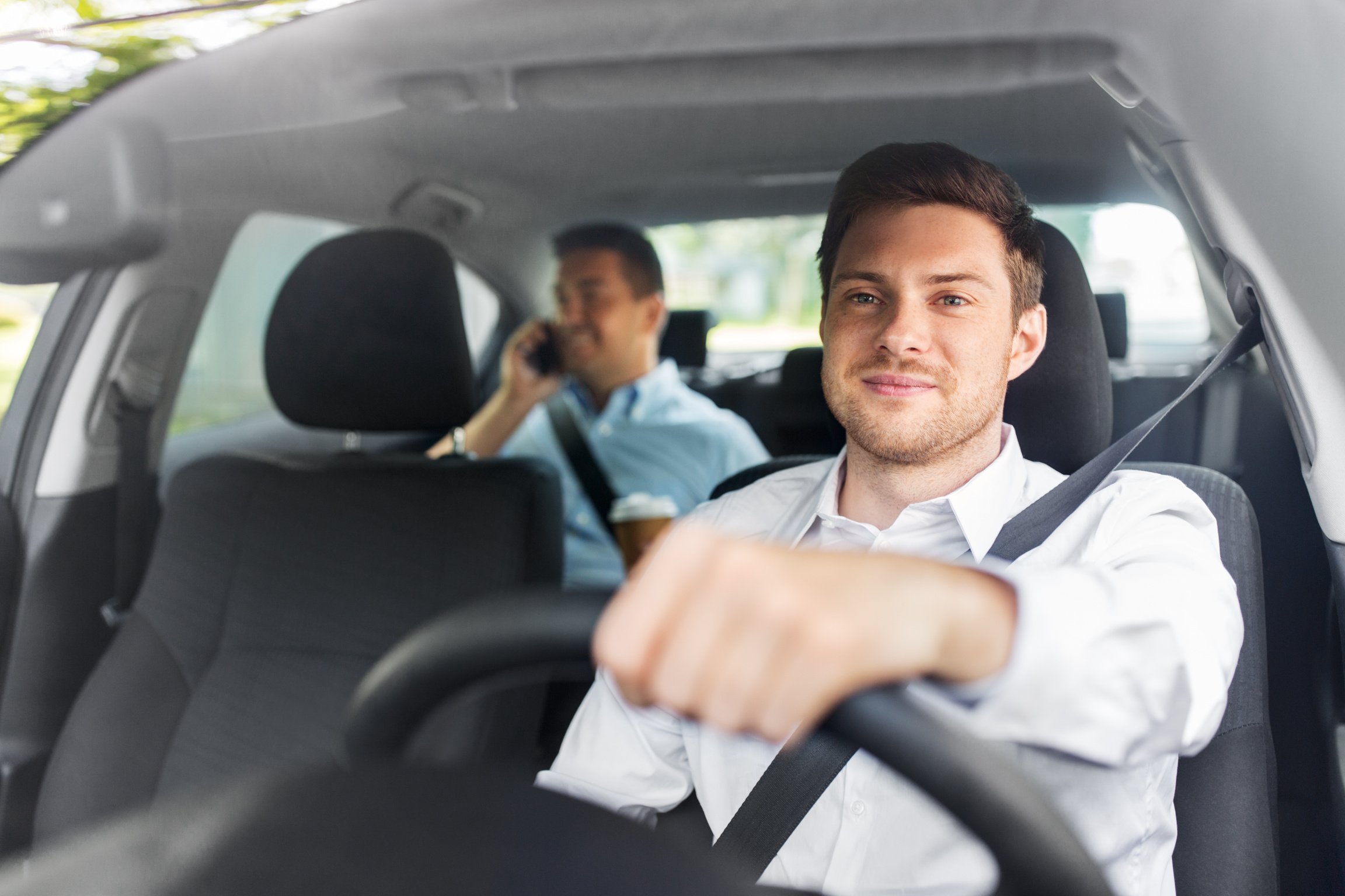 Male Driver Driving Car with Passenger